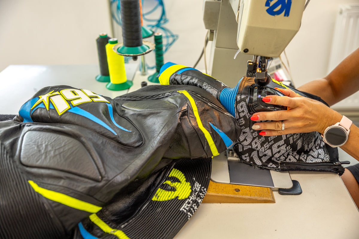 Technician sewing a motorcycle leather racing suit